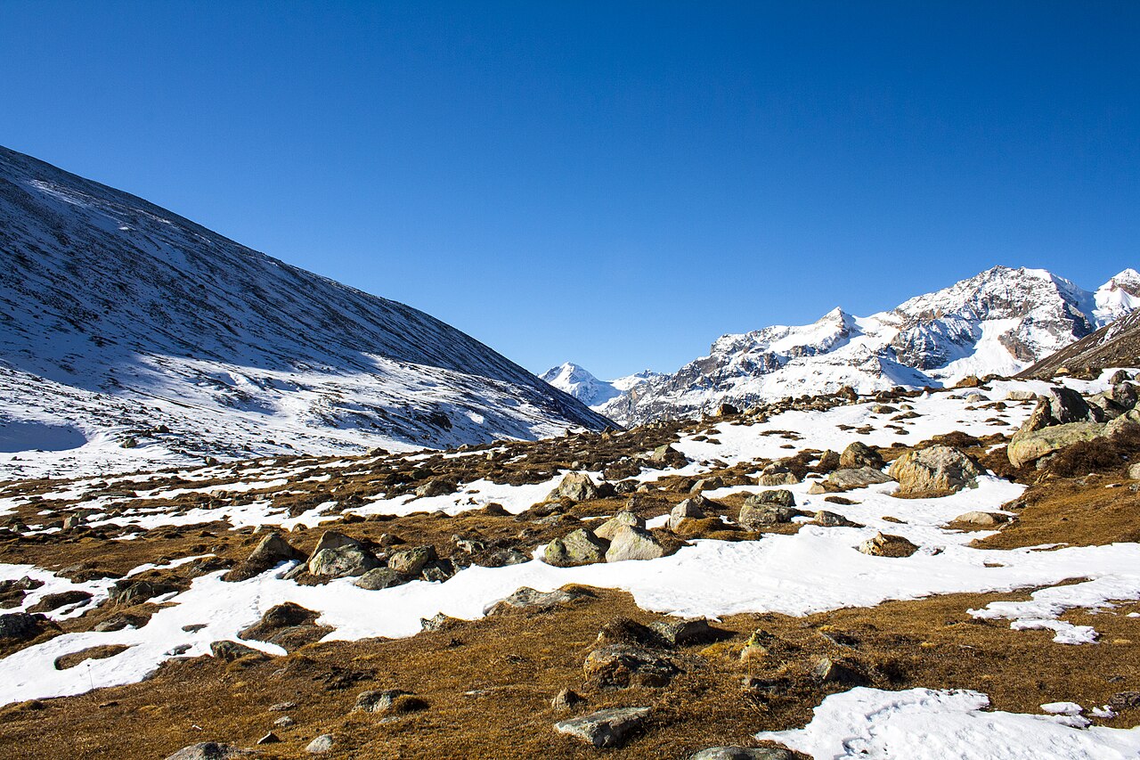 Yumthang river flowing gracefully through pristine snowy mountain valleys